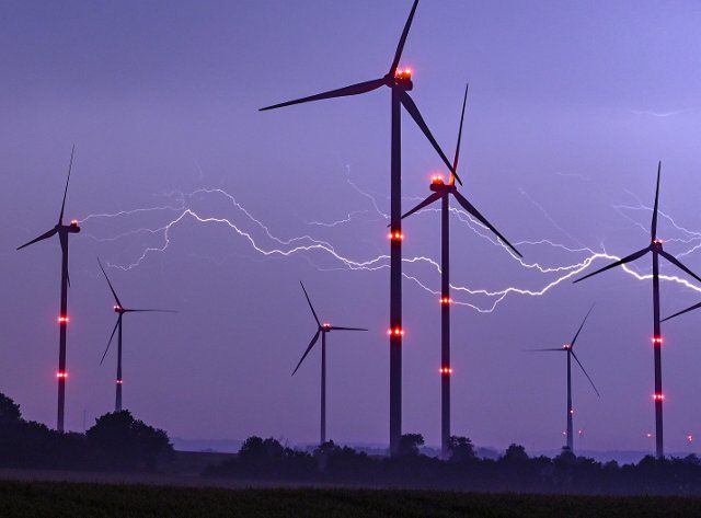 20 May 2022, Brandenburg, Jacobsdorf: A flash lights up the night sky above wind turbines with red position lights. Photo: Patrick Pleul\/dpa