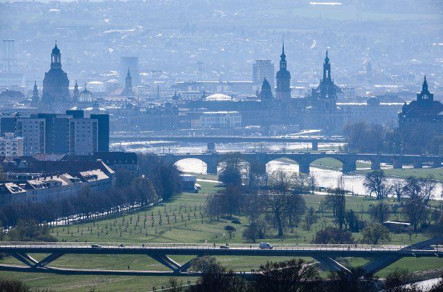12 April 2022, Saxony, Dresden: View of the city center on the Elbe with the Frauenkirche (l-r), the dome of the Kunstakedmie with the angel "Fama", the Ständehaus, the Hausmannsturm, the Hofkirche and the State Chancellery, in the foreground the Waldschlößchenbrücke, in the middle the Albertbrücke and in the background the Carolabrücke can be seen. Photo: Robert Michael\/dpa