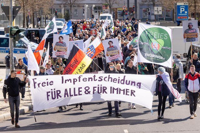 16 April 2022, Thuringia, Erfurt: A march against the Corona policy is led by a banner reading "Free Vaccination Choice for All & Forever." Photo: Michael Reichel\/dpa-Zentralbild\/dpa