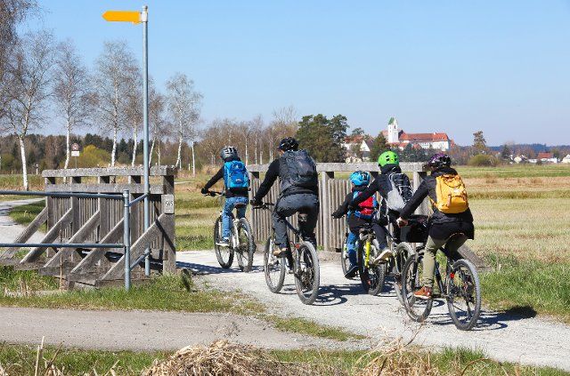 18 April 2022, Baden-Wuerttemberg, Bad Buchau: Cyclists are on the bike path around the Federsee. With an area of around 1.4 square kilometers, Federsee near Bad Buchau in Upper Swabia (Biberach district) is the second largest lake in Baden-Württemberg. Photo: Thomas Warnack\/dpa