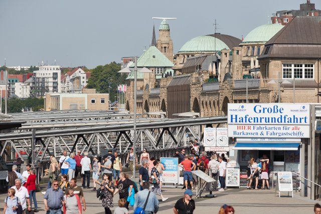 18 June 2022, Hamburg: People are walking on the landing stages. A ticket office with the inscription "Great harbor tour" can be seen. Photo: Georg Wendt\/dpa