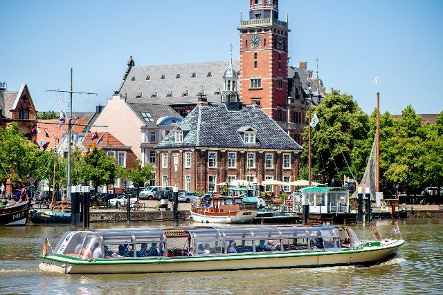 23 June 2022, Lower Saxony, Leer: The excursion ship "Koralle" is underway in sunny weather during a harbor cruise in the harbor in front of the city hall of the city. Photo: Hauke-Christian Dittrich\/dpa