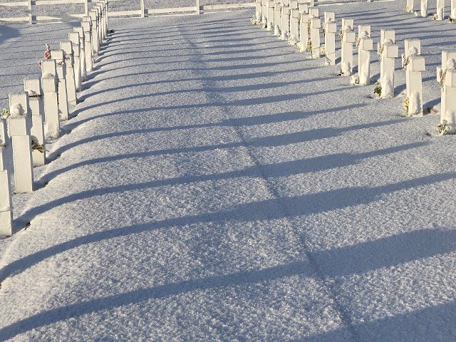 20 June 2022, Great Britain, Stanley: Crosses in the Argentine war cemetery cast shadows on the snow. Photo: Benedikt von Imhoff\/dpa