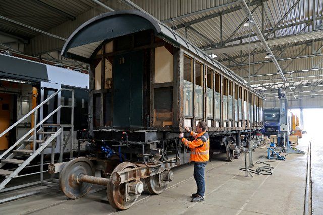 20 May 2022, Saxony-Anhalt, Halberstadt: Railroad operations manager Michael Brandes inspects a wooden wagon of a Swiss private railroad. The medium-sized company, VIS Verkehrs Industrie Systeme GmbH, with its 254 employees specializes in railroad technology. Photo: Peter Gercke\/dpa
