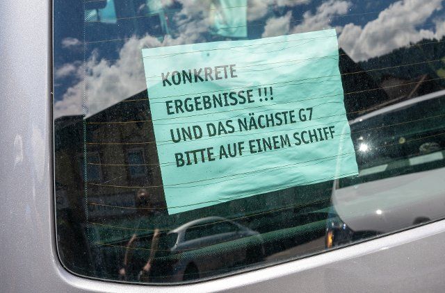25 June 2022, Bavaria, Garmisch-Partenkirchen: A piece of paper with the inscription "Concrete results !!! - And the next G7 please on a ship" hangs in a car parked in the city center. Germany is hosting the G7 summit of economically strong democracies. On the first day of the summit, the global economic situation, climate protection and foreign and security policy with the sanctions against Russia will be discussed. Photo: Peter Kneffel\/dpa