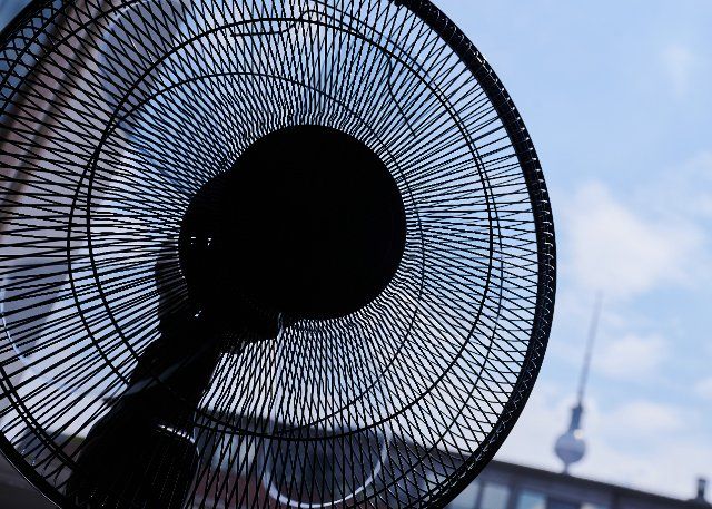 25 June 2022, Berlin: In one apartment, the fan is running outside the window near the TV tower. There is sultry heat in Berlin on the weekend. Photo: Annette Riedl\/dpa