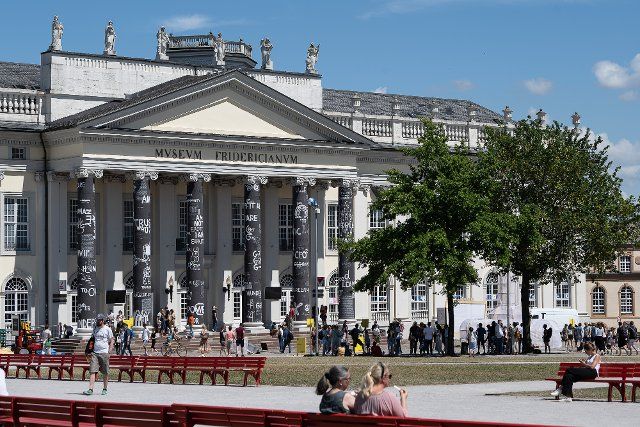 25 June 2022, Hessen, Kassel: Visitors stand in front of the Museum Fridericianum at the documenta fifteen. The art exhibition goes until 25.09.2022. Photo: Swen Pförtner\/dpa