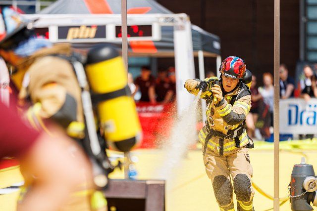 25 June 2022, Lower Saxony, Hanover: A female firefighter starts a firefighting attack on a course at the "FireFit European Championships" competition on the exhibition grounds. The "Interschutz" trade show is the world\