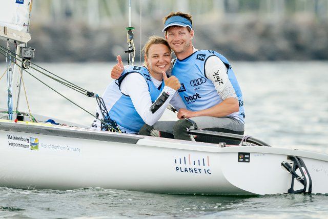 25 June 2022, Schleswig-Holstein, Kiel: Sailing: Kiel Week, in front of the Olympic Center in Schilksee. Helmsman Malte Winkel and his foresailor and wife Anastasiya Winkel give the thumbs up after sailing in the 470 class. Photo: Sascha Klahn\/dpa
