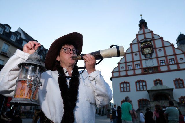 25 June 2022, Saxony, Plauen: Almut Gattermann in the role of the Türmerin von Hameln and representative of the Guild of Night Watchmen, Türmer und Figuren e.V., stands in front of the town hall. About 40 participants from Germany and Austria met in the Vogtland town at the weekend. Photo: Sebastian Willnow\/dpa