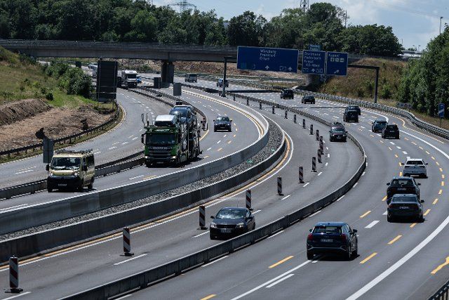 25 June 2022, Hessen, Kassel: Cars and trucks drive through a construction site on the A7 highway near Kassel. Photo: Swen Pförtner\/dpa