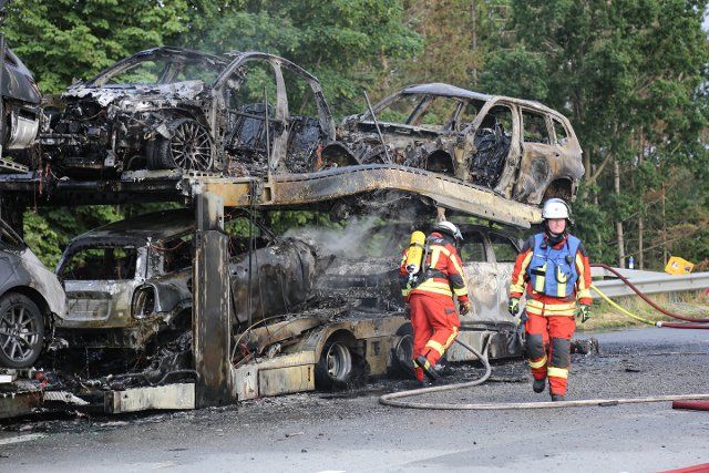 25 June 2022, Schleswig-Holstein, Neumünster: Firefighters stand by a burned-out car transporter on the A7. After the truck caught fire, the highway had to be closed for about seven hours in the direction of Flensburg. The police suspect a technical defect in a tire as the cause. Photo: Thomas Nyfeler\/fdpa\/dpa