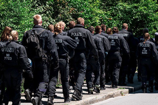 26 June 2022, Bavaria, Garmisch-Partenkirchen: Police forces head toward the train station. The first day of the summit will focus on the global economic situation, climate protection and foreign and security policy - especially sanctions against Russia. Photo: Daniel Vogl\/dpa