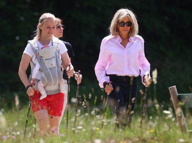 26 June 2022, Bavaria, Elmau: Miriam Neureuther, former biathlete (l-r) with child in baby carrier, Amelie Derbaudrenghien (hidden behind) , partner of EU Council President Charles Michel, and Brigitte Macron, wife of French President Emmanuel Macron, on a joint Nordic walking tour. On the first day of the summit, the global economic situation, climate protection and foreign and security policy with the sanctions against Russia will be discussed. Photo: Karl-Josef Hildenbrand\/dpa