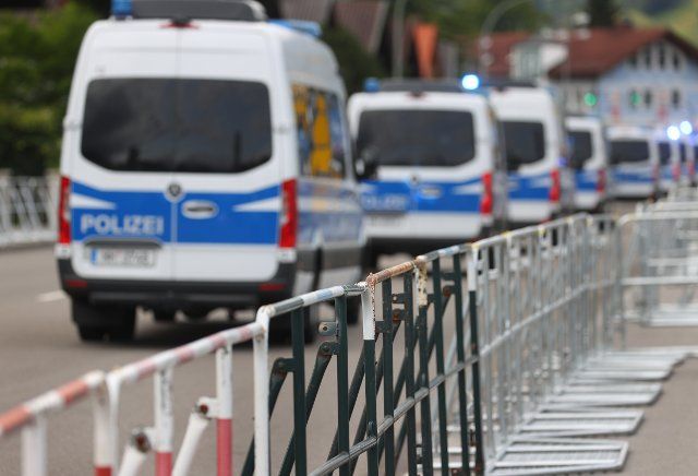 28 June 2022, Bavaria, Garmisch-Partenkirchen: Police emergency vehicles drive behind barriers. Germany hosted the G7 summit at Schloss Elmau. Photo: Karl-Josef Hildenbrand\/dpa
