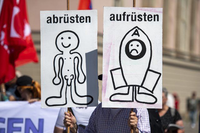 02 July 2022, Berlin: A participant holds two posters at a demonstration under the slogan "We won\
