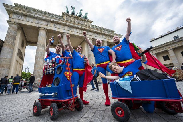 dpatop - 26 May 2022, Berlin: Men dressed as Superman celebrate Father\