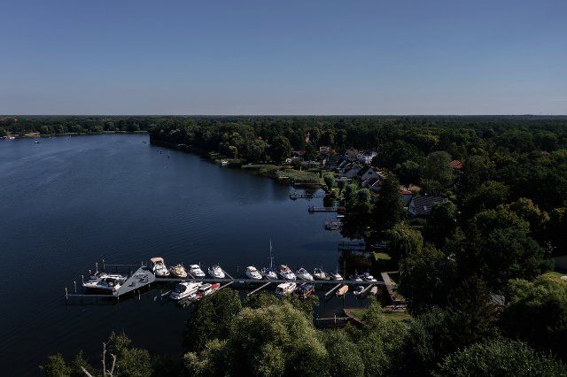 03 August 2022, Brandenburg, Oranienburg: Boats are anchored at a pier on the Lehnitzsee lake in Oranienburg, Brandenburg, Germany. (Aerial photo taken with a drone). Photo: Paul Zinken\/dpa