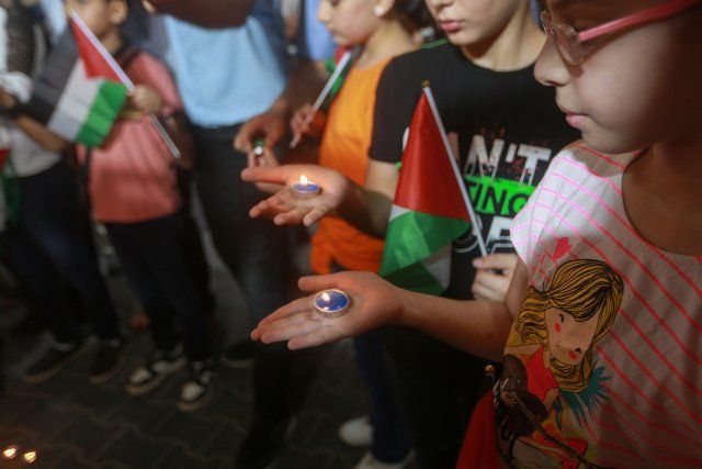 11 August 2022, Palestinian Territories, Gaza City: Children hold candles during a vigil inside Shifa Hospital for child victims during the recent military conflict between Israel and the Palestinian resistance. Three days after exchanging rocket attacks and air strikes that killed at least 44 Palestinians and injured 360 others, ccording to the Palestinian Ministry of Health. Photo: Mohammed Talatene\/dpa