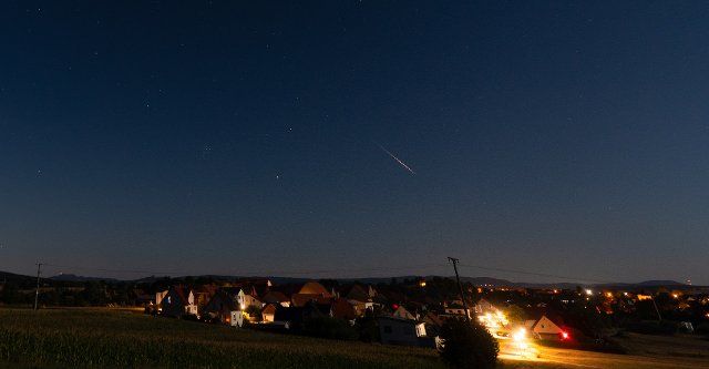 12 August 2022, Bavaria, Höfen: A shooting star burns up in the night sky. Saturday morning is expected to be the peak of the Perseid shooting stars. Earth flies through the debris cloud of a comet these days. Photo: Nicolas Armer\/dpa
