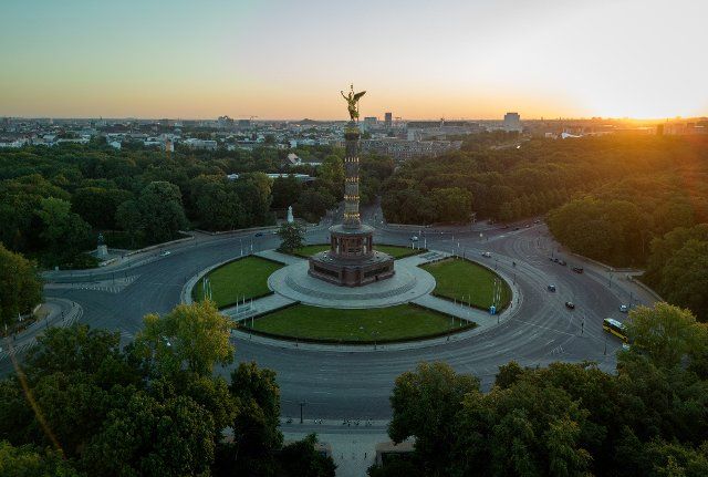 12 August 2022, Berlin: The sun rises behind the Victory Column in Berlin this morning. Meteorologists continue to forecast midsummer weather for the capital. Photo: Kay Nietfeld\/dpa
