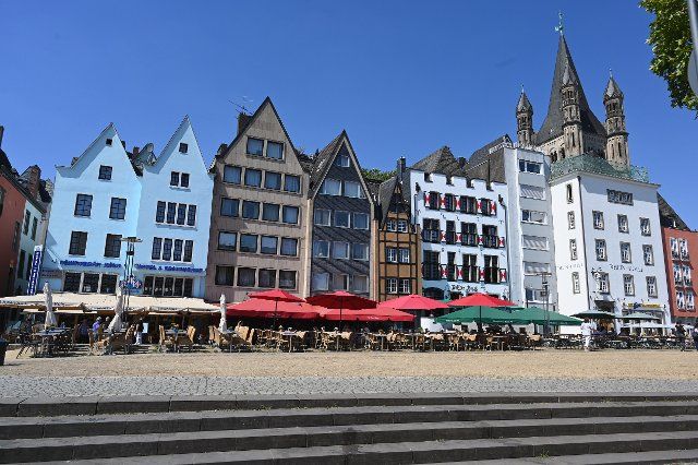 11 August 2022, North Rhine-Westphalia, Cologne: Gabled houses with outdoor gastronomy in the old town of Cologne Photo: Horst Galuschka\/dpa