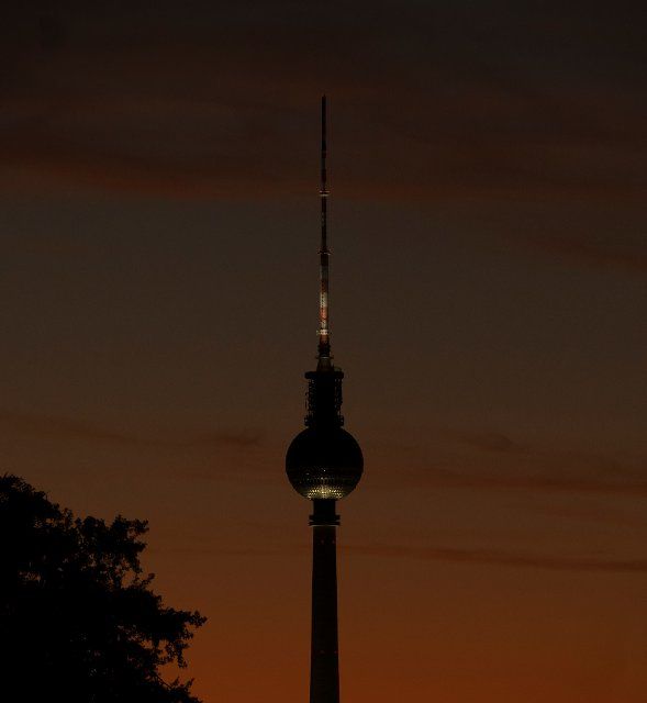 11 August 2022, Berlin: The setting sun colors the sky behind the TV tower in a special light. Photo: Paul Zinken\/dpa