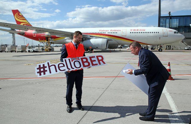 12 August 2022, Brandenburg, Schönefeld: Thomas Hoff Andersson (l), COO Berlin Brandenburg Airport, and Stefan Pampel, Account Manager of Hainan Airlines, stand in front of one of the airline\