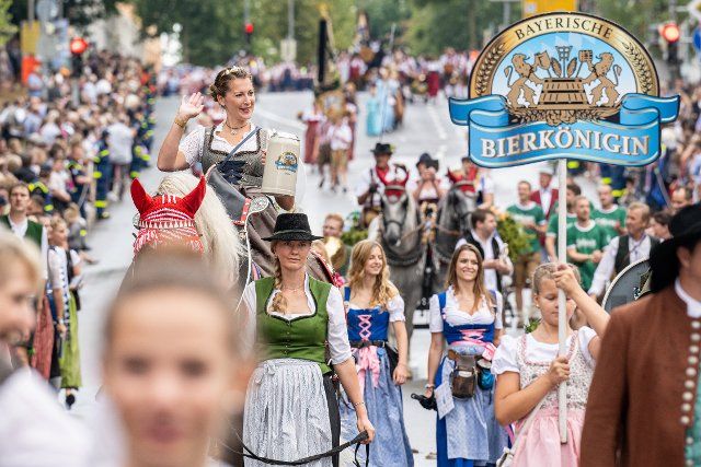 12 August 2022, Bavaria, Straubing: The Bavarian Beer Queen, Sarah Jäger parades through the city center during the traditional procession to the Gäuboden Folk Festival. After a two-year forced break from Corona, Straubing is once again hosting the traditional folk festival. Photo: Armin Weigel\/dpa