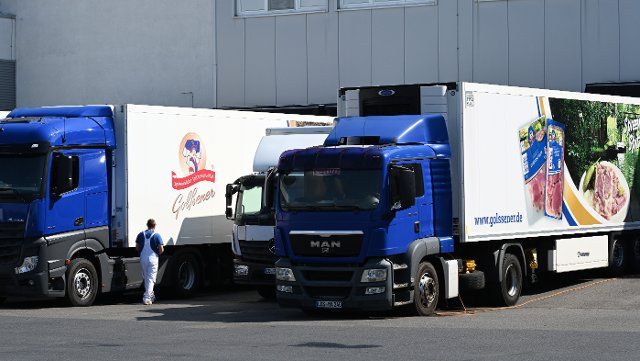 16 August 2022, Brandenburg, Golßen: Trucks stand at the loading bay of Golßener Lebensmittel GmbH & Co. Produktions KG. In addition to sausages and delicatessen salads, the company produces Spreewälder Gurkensülze, which has carried the EU seal "Protected Geographical Indication" since June 16, 2022. The aspic with Spreewald gherkins and a high lean meat content was first produced industrially in 1955. Photo: Bernd Settnik\/dpa\/ZB