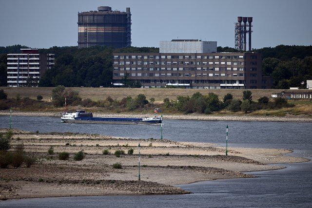 16 August 2022, North Rhine-Westphalia, Duisburg: A cargo ship sails on the Rhine. After weeks of drought, the water levels of the Rhine have reached historic lows. Photo: Federico Gambarini\/dpa