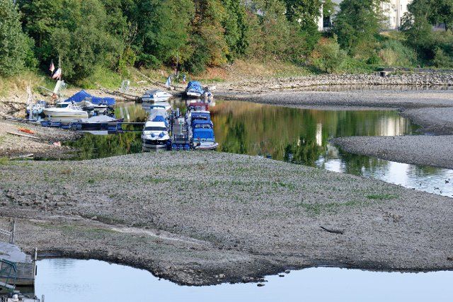 16 August 2022, North Rhine-Westphalia, Bad Honnef: Boats lie dry in the almost dry Rhine arm between Bad Honnef and the Rhine island Grafenwerth. Photo: Henning Kaiser\/dpa