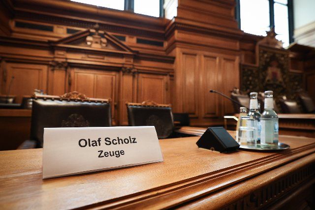 19 August 2022, Hamburg: A plastic sign with the text "Olaf Scholz witness" stands on a seat on the Senate bench before the start of a meeting of the Parliamentary Investigation Committee "Cum-Ex" in the plenary hall of the Hamburg Parliament in the City Hall. In the afternoon, Chancellor Olaf Scholz (SPD) will again testify before the committee. Photo: Christian Charisius\/dpa