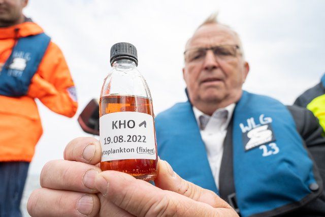 19 August 2022, Mecklenburg-Western Pomerania, Ueckermünde: Till Backhaus (SPD), State Environment Minister of Mecklenburg-Western Pomerania, shows a chemically fixed water sample from the Szczecin Lagoon. Employees of the State Office for Agriculture and the Environment of Western Pomerania (StALU VP) have taken further water samples. So far, according to official information, no fish carcasses have been discovered in the German part of the lagoon in connection with the Oder fish kill. Nevertheless, as a precautionary measure, authorities advise against swimming, fishing, and water withdrawal from the Szczecin Lagoon. Tourism businesses have already reported a drop in visitors. The German-Polish border river Oder flows into the Szczecin Lagoon, through which the German-Polish border runs and which is connected to the Baltic Sea. The estuary is widely branched and the Haff, at around 900 square kilometers, is about twice the size of Lake Constance. Photo: Stefan Sauer\/dpa