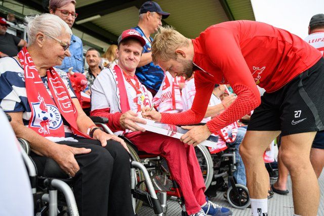 21 August 2022, Leipzig: Konrad Laimer signs autographs at the public training session for the inclusive fan day at RB Leipzig. Photo: Christian Modla\/dpa