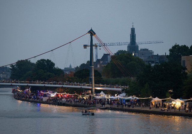 26 August 2022, Hessen, Frankfurt\/Main: The banks of the Main River in Frankfurt are brightly lit for the start of the Museumsuferfest. Up to one million visitors are expected in the coming days. Photo: Boris Roessler\/dpa