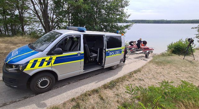 18 July 2022, Saxony-Anhalt, Bergwitz: With the help of sonar technology, police forces continue to search for a missing stand-up paddler in the Bergwitzsee lake near Kemberg (Wittenberg district). According to witnesses, the 47-year-old had fallen from his stand-up paddle board into the lake on July 16, 2022, and had not resurfaced. Photo: Tobias Junghannß\/dpa-Zentralbild\/dpa
