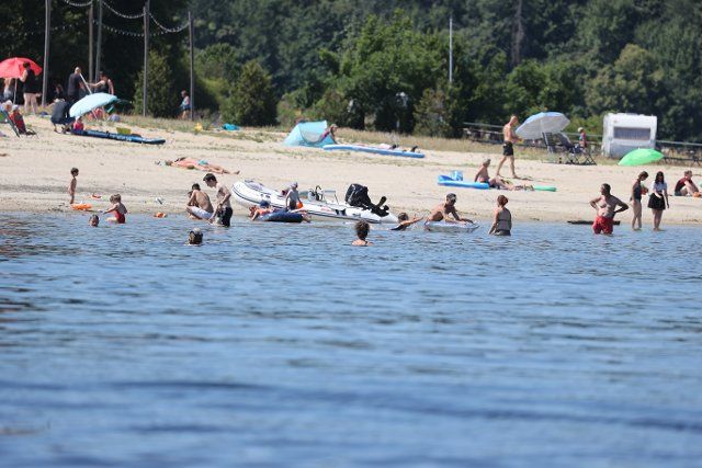 19 July 2022, Thuringia, Saalburg: Bathers swim in the water of the Bleiloch dam in midsummer temperatures. Photo: Bodo Schackow\/dpa