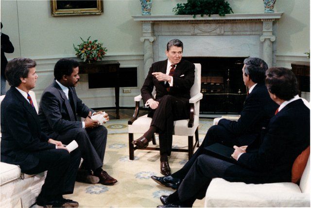 United States President Ronald Reagan makes a point during an interview with television network anchors in the Oval Office of the White House in Washington, D.C. on Thursday, December 3, 1987. Seated, from left, are: Tom Brokaw of NBC; Bernard Shaw of CNN; President Reagan; Dan Rather of CBS; and Peter Jennings of ABC. .Mandatory Credit: Bill Fitz-Patrick - White House via CNP