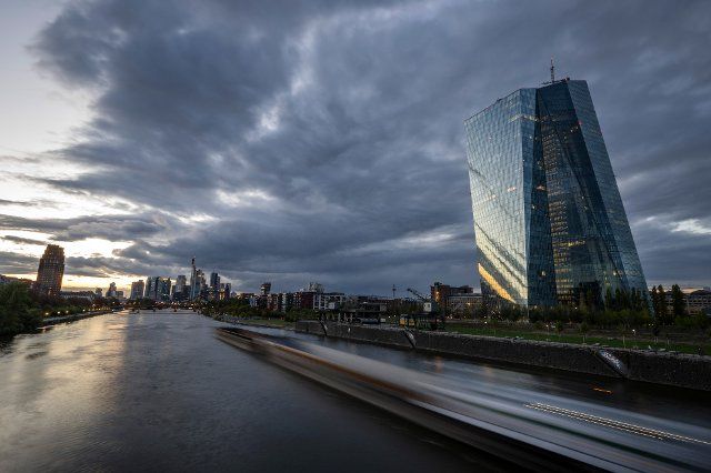 20 September 2022, Hessen, Frankfurt\/Main: A cargo ship sails past the headquarters of the European Central Bank (ECB, r) on the Main River shortly after sunset (long exposure shot). Photo: Boris Roessler\/dpa