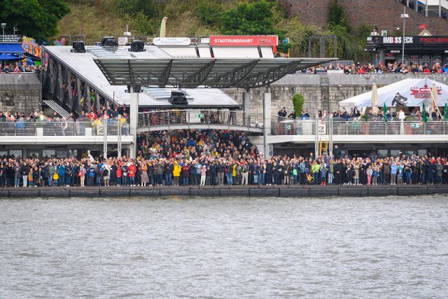 17 September 2022, Hamburg: Onlookers stand packed on the landing stages waiting for the traditional tugboat ballet. Photo: Jonas Walzberg\/dpa