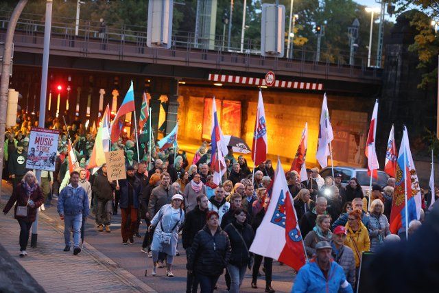 26 September 2022, Thuringia, Gera: Participants of a demonstration against the energy policy of the federal government and against Corona measures walk through the city center in the evening. Several thousand people took part in the demonstration. Photo: Bodo Schackow\/dpa