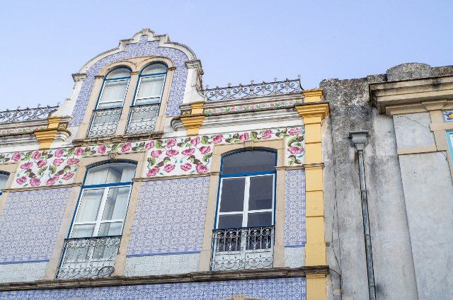 PRODUCTION - 13 August 2022, Portugal, Tomar: A house decorated with ceramic tiles in downtown Tomar, next to it a gray facade. Photo: Viola Lopes\/dpa