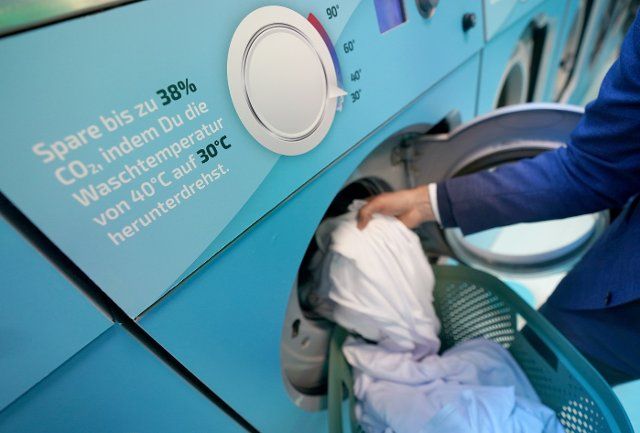 27 September 2022, Hamburg: A man fills a washing machine during the Cold Laundromat campaign in the Winterhude district. From Friday to Sunday, citizens can wash their laundry free of charge at a maximum of 30 degrees. Initiators of the campaign are the environmental foundation WWF and detergent manufacturer Ariel (consumer goods group Procter & Gamble). (to dpa "More washing with only 30 degrees - cold laundromat should achieve rethinking") Photo: Marcus Brandt\/dpa