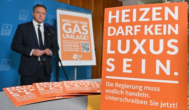 27 September 2022, Thuringia, Erfurt: Mario Voigt, CDU state leader in Thuringia, speaks in front of a poster reading "Away with the gas levy" about what is expected of Thuringia\