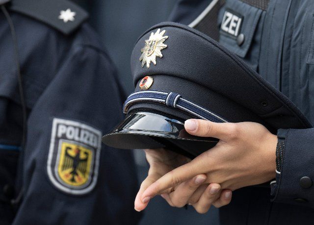 27 September 2022, Hessen, Frankfurt\/Main: A young federal police officer holds her cap at the swearing-in ceremony of the Federal Police Headquarters at Frankfurt Airport. At the swearing-in ceremonies, which take place every six months, the young officers are officially taken into service. Photo: Boris Roessler\/dpa