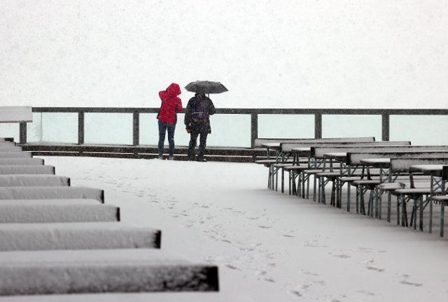 27 September 2022, Bavaria, Oberstdorf: Excursionists stand in the snow flurry at the Fellhornbahn middle station, 1780 meters above sea level. Photo: Karl-Josef Hildenbrand\/dpa
