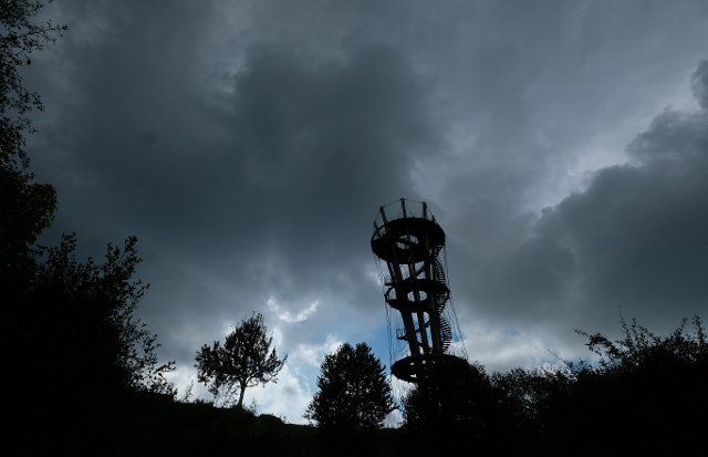 30 September 2022, Baden-Wuerttemberg, Herrenberg: Dark clouds with a hole of sunshine cover the sky above the Schönbuchturm near Herrenberg. Photo: Bernd Weißbrod\/dpa