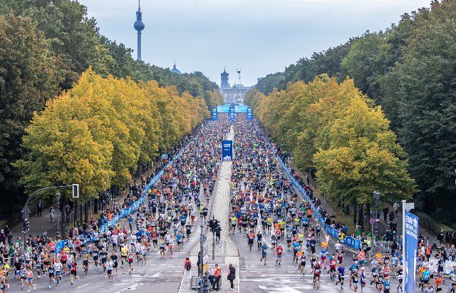25 September 2022, Berlín: The 17 June street in the capital of Berlin, with the Brandenburg Gate and the television tower in the background, during the marathon in the German capital. Reigning Olympic marathon champion Eliud Kipchoge broke the world record for the distance in Berlin again today after running the 42.195 kilometers in 2:01:09 hours, beating Kipchoge\