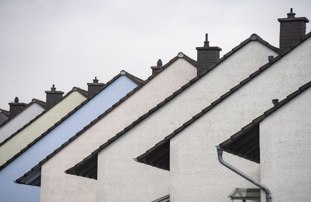25 September 2022, Rhineland-Palatinate, Mainz: The roofs and chimneys of row houses can be seen on the edge of a street in Mainz. Drastically rising energy costs are currently causing problems for many tenants and homeowners. Photo: Frank Rumpenhorst\/dpa